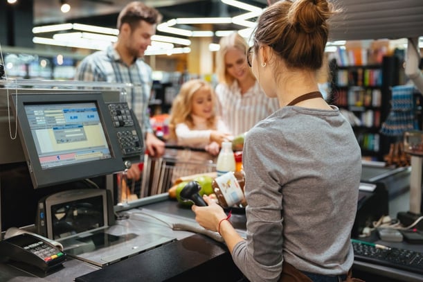 A cashier enrolling a customer into a loyalty program
