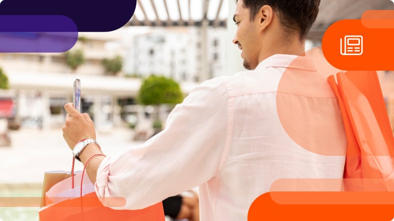 back of man holding shopping bags and smartphone