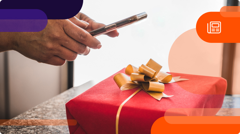 person holding phone with a gift on the table